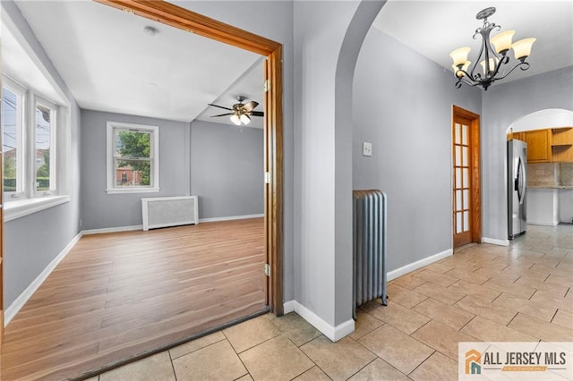 74 Charles St, Carteret, NJ 07008 - corridor with arched walkways, radiator heating unit, a chandelier, and baseboards