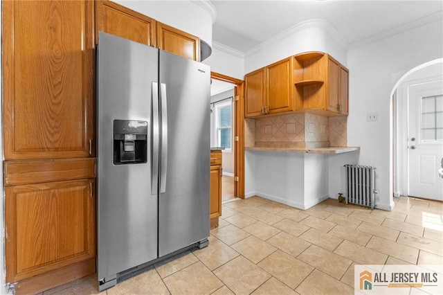 74 Charles St, Carteret, NJ 07008 - kitchen featuring stainless steel refrigerator with ice dispenser, radiator heating unit, open shelves, arched walkways, and backsplash