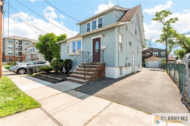 74 Charles St, Carteret, NJ 07008 - view of front facade featuring a garage, driveway, and an outdoor structure