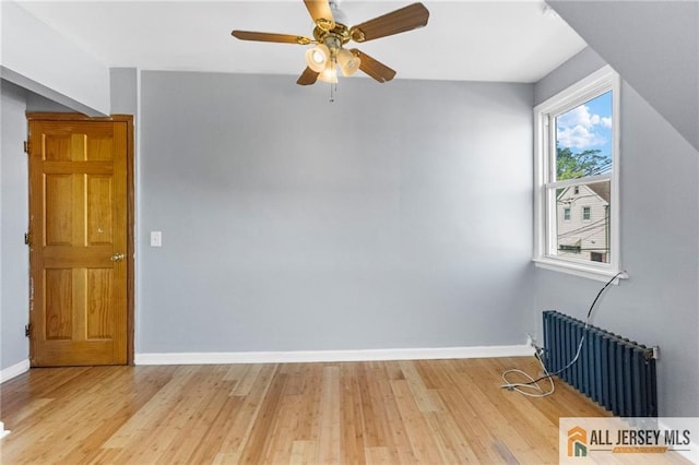 74 Charles St, Carteret, NJ 07008 - unfurnished room featuring radiator, light wood-type flooring, and ceiling fan