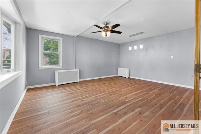 74 Charles St, Carteret, NJ 07008 - spare room with radiator, a ceiling fan, wood finished floors, and baseboards