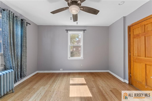 74 Charles St, Carteret, NJ 07008 - spare room featuring radiator, wood finished floors, a ceiling fan, and baseboards