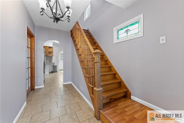 74 Charles St, Carteret, NJ 07008 - staircase featuring arched walkways, a chandelier, plenty of natural light, and baseboards