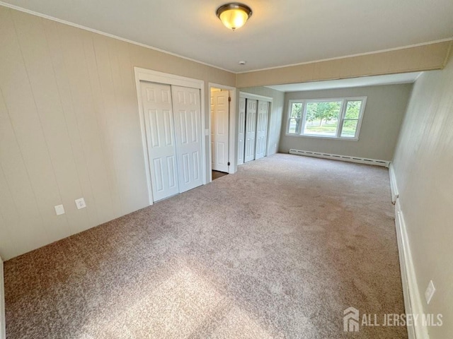1154 Foster Ave, South Plainfield, NJ 07080 - unfurnished bedroom featuring a baseboard heating unit, carpet, multiple closets, and ornamental molding