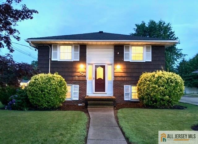 323 Green St, Woodbridge Proper, NJ 07095 - bi-level home featuring a front lawn and brick siding