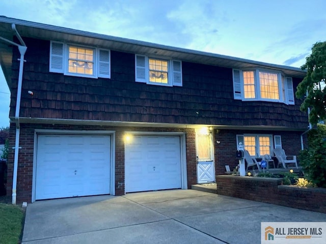 323 Green St, Woodbridge Proper, NJ 07095 - view of front facade featuring driveway, an attached garage, brick siding, and mansard roof