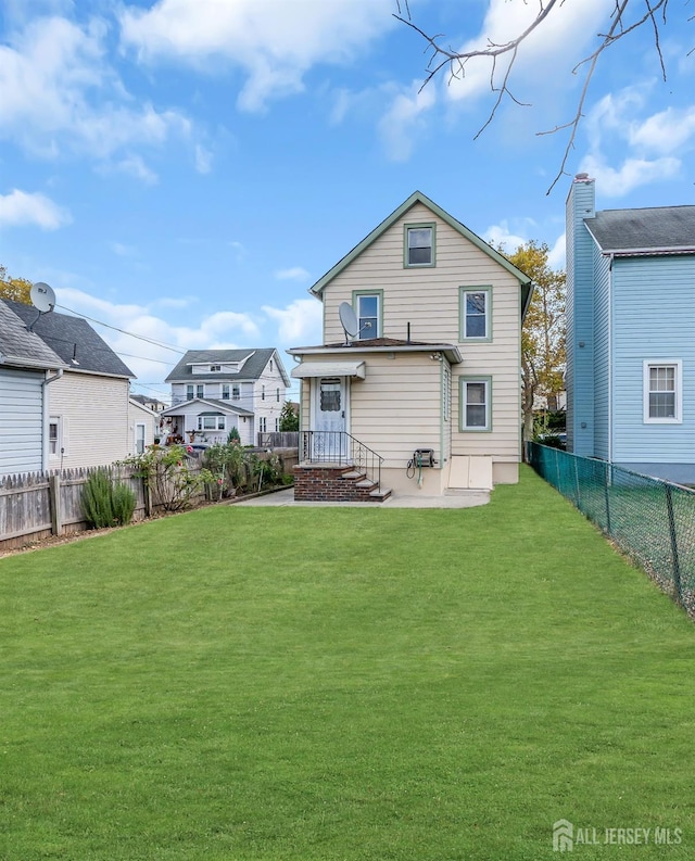 back of house featuring a lawn and a patio