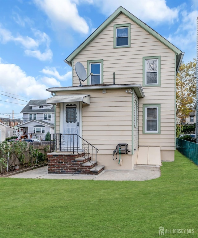 back of property with a yard and a patio area