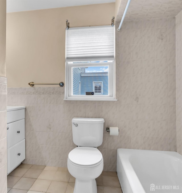 bathroom with tile walls, vanity, tile patterned flooring, and toilet