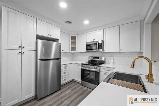 kitchen with stainless steel appliances, sink, and white cabinets