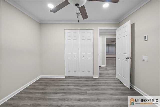 unfurnished bedroom featuring crown molding, wood finished floors, and baseboards