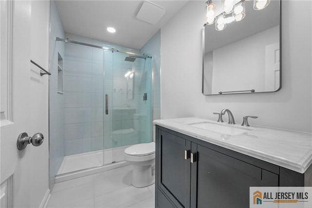 bathroom with tile patterned floors, vanity, toilet, and a shower stall