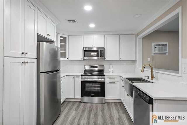 kitchen featuring white cabinetry, appliances with stainless steel finishes, sink, and a wall mounted air conditioner