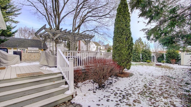 yard layered in snow with a wooden deck, an outdoor kitchen, and a pergola