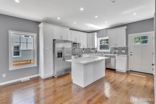 65 Bayview St, Aberdeen, NJ 07721 - kitchen featuring stainless steel appliances, plenty of natural light, tasteful backsplash, white cabinetry, and recessed lighting