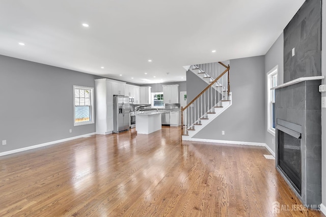 65 Bayview St, Aberdeen, NJ 07721 - unfurnished living room featuring stairs, a large fireplace, light wood-type flooring, and recessed lighting