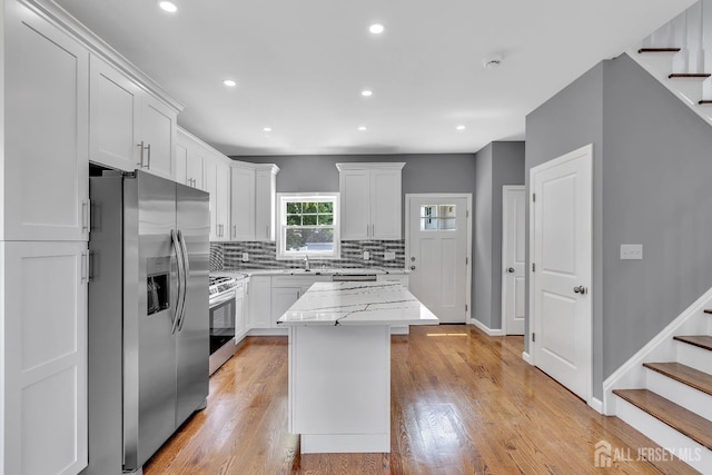65 Bayview St, Aberdeen, NJ 07721 - kitchen featuring stainless steel appliances, decorative backsplash, white cabinets, light stone countertops, and recessed lighting