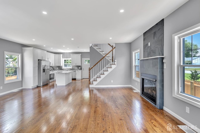 65 Bayview St, Aberdeen, NJ 07721 - unfurnished living room with a large fireplace, plenty of natural light, stairs, recessed lighting, and wood finished floors