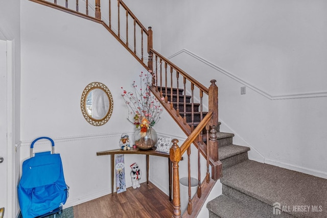 staircase featuring baseboards and wood finished floors