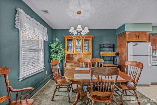 dining space featuring a textured ceiling and a notable chandelier