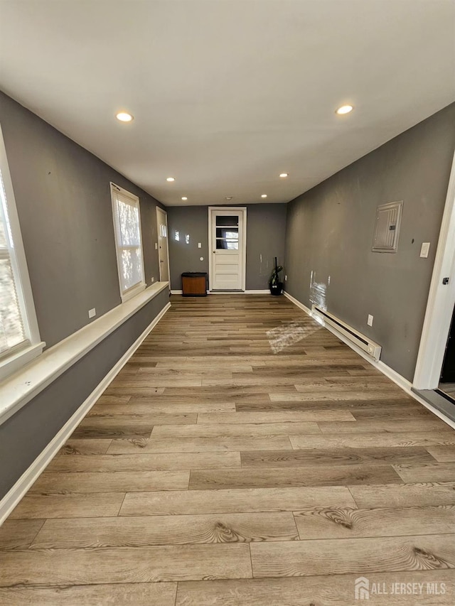 interior space featuring baseboard heating and light hardwood / wood-style floors