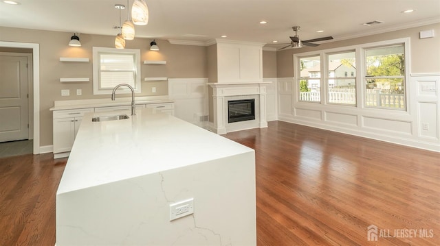 kitchen featuring a sink, ceiling fan, dark wood-style flooring, white cabinets, and ornamental molding