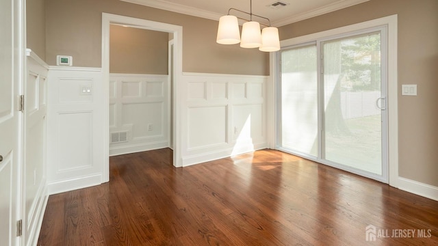unfurnished dining area featuring ornamental molding, a decorative wall, wood finished floors, and wainscoting