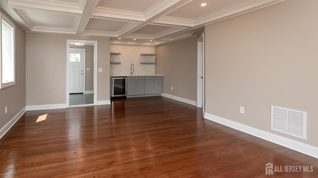 unfurnished living room with wine cooler, baseboards, dark wood finished floors, recessed lighting, and coffered ceiling