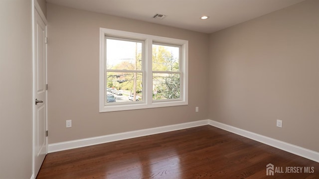 empty room featuring dark wood finished floors, baseboards, and recessed lighting