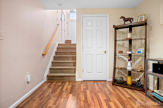 stairs with wood finished floors and baseboards