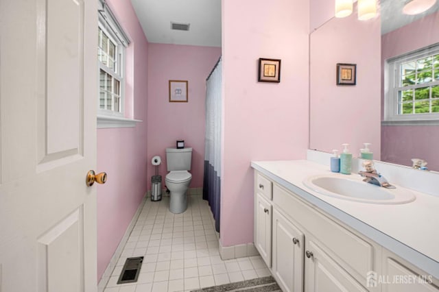 bathroom with tile patterned flooring, toilet, vanity, curtained shower, and baseboards