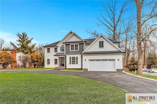 view of front facade featuring board and batten siding, stone siding, a front lawn, and aphalt driveway