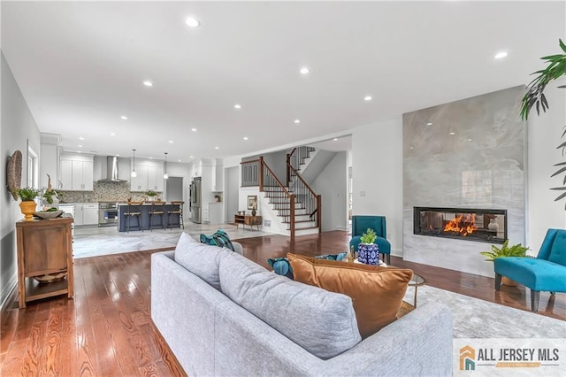 living room featuring a tile fireplace and light hardwood / wood-style flooring