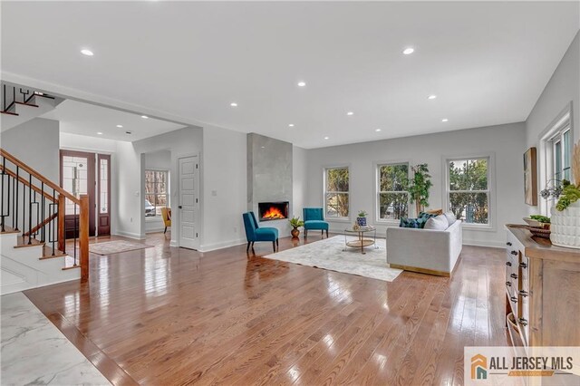 living room with a fireplace and light wood-type flooring