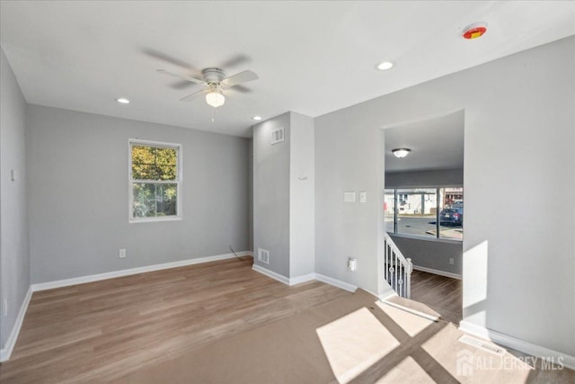 empty room with hardwood / wood-style floors, a wealth of natural light, and ceiling fan