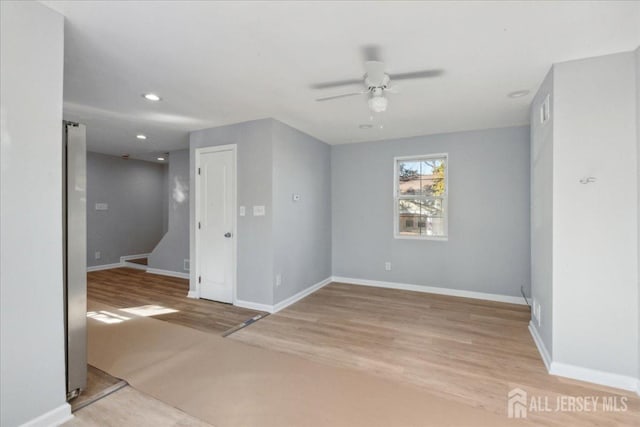 empty room with light hardwood / wood-style flooring and ceiling fan