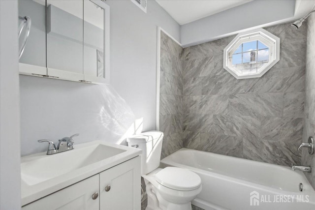 full bathroom featuring tiled shower / bath combo, vanity, and toilet