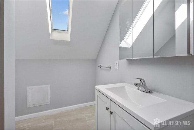 bathroom featuring vanity and vaulted ceiling with skylight