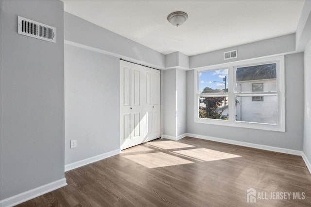 unfurnished bedroom featuring wood-type flooring and a closet