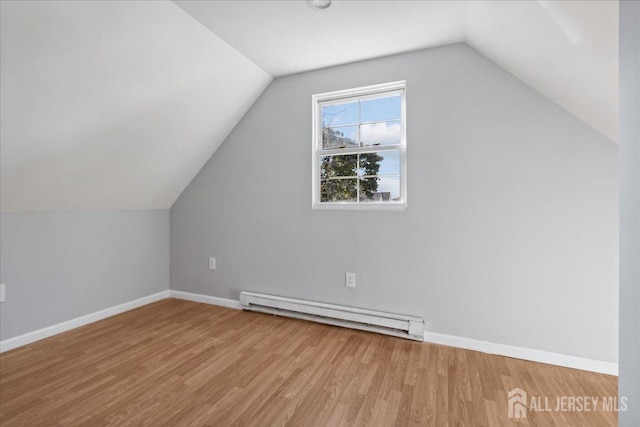 additional living space featuring baseboard heating, lofted ceiling, and wood-type flooring