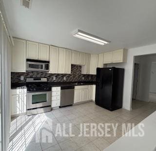 284 Brookfield Dr, Jackson, NJ 08527 - kitchen with appliances with stainless steel finishes, tasteful backsplash, cream cabinets, light tile patterned flooring, and dark countertops