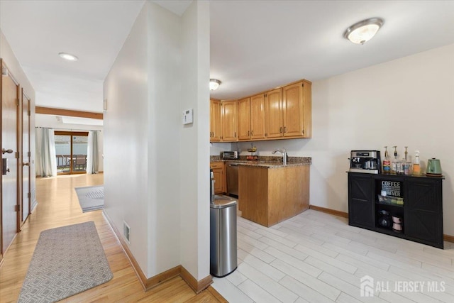 675 Raritan Rd, Clark, NJ 07066 - kitchen featuring stainless steel dishwasher, baseboards, a sink, light wood-style floors, and dark stone countertops
