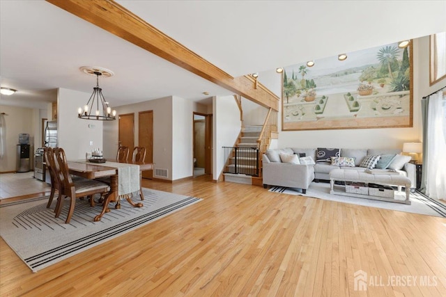 675 Raritan Rd, Clark, NJ 07066 - dining area featuring light wood-style flooring, stairway, a chandelier, and beamed ceiling