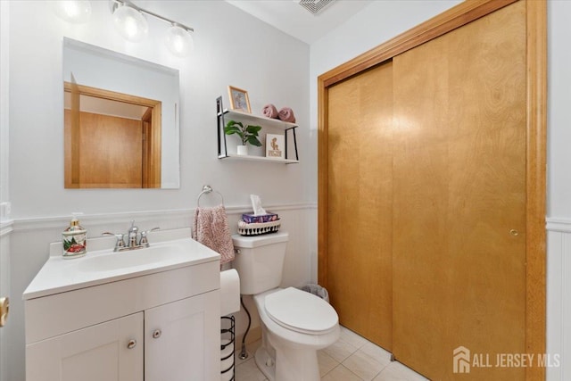 675 Raritan Rd, Clark, NJ 07066 - bathroom with vanity, toilet, wainscoting, and tile patterned floors
