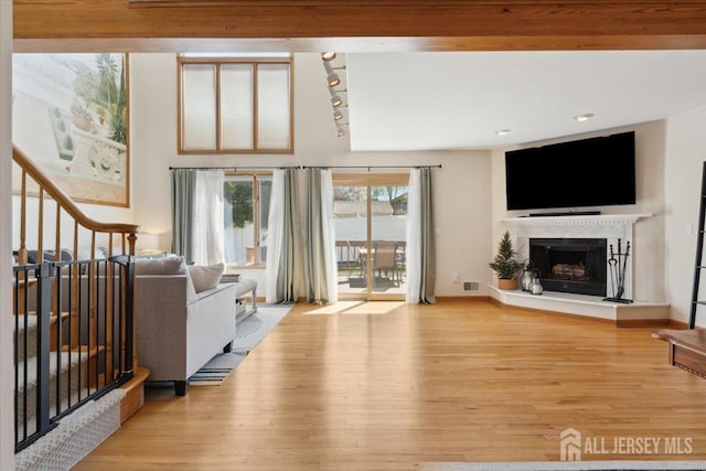 675 Raritan Rd, Clark, NJ 07066 - living room with wood finished floors, a fireplace with raised hearth, track lighting, and baseboards