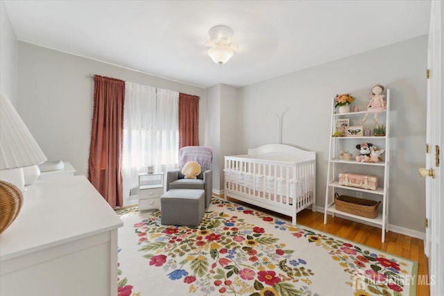 675 Raritan Rd, Clark, NJ 07066 - bedroom featuring light wood-style floors, a crib, and baseboards