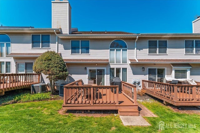 675 Raritan Rd, Clark, NJ 07066 - back of property featuring cooling unit, a chimney, a wooden deck, and a yard
