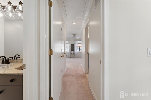 675 Raritan Rd, Clark, NJ 07066 - corridor featuring light carpet, attic access, ornamental molding, a sink, and baseboards