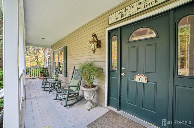 view of exterior entry featuring covered porch