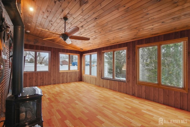 42 Frederick St, Carteret, NJ 07008 - unfurnished sunroom featuring wooden ceiling, a wood stove, wood finished floors, and a wealth of natural light